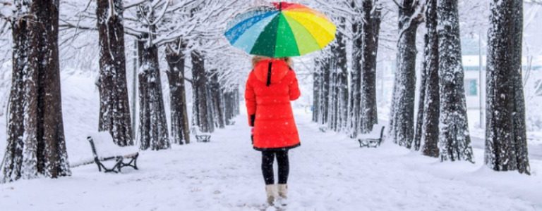 Frau mit farbiger Kleidung im Schnee